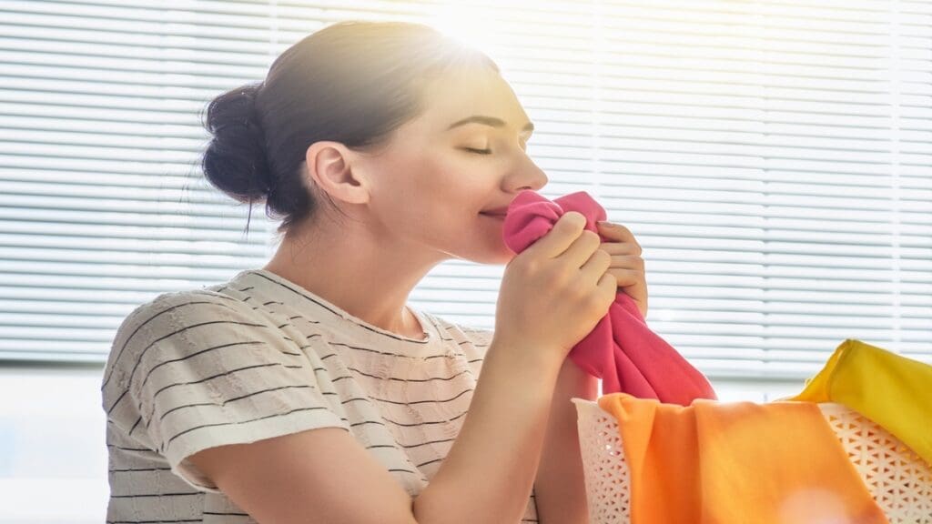a woman sniffing fresh clothes.