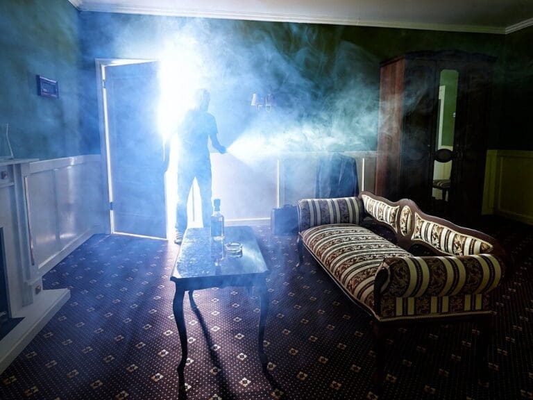 a man entering from a door in a room and a smoke cloud can see in room.
