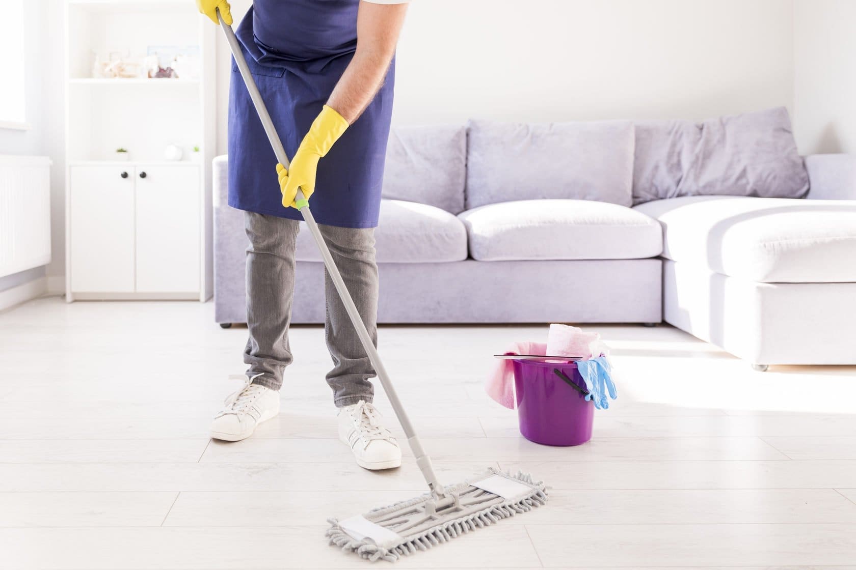 a person cleaning floor with mop.